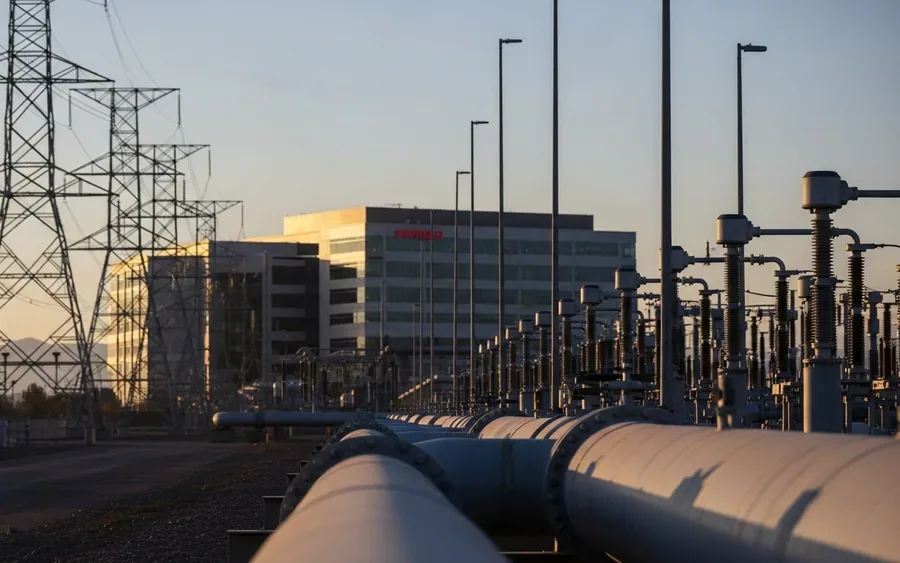 Сучасна енергетична інфраструктура Sempra Energy на заході сонця, що включає газопровід або лінії електропередач та корпоративну будівлю на фоні.
